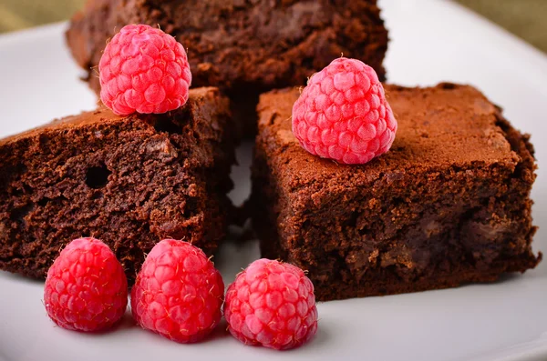 Huisgemaakte chocolade brownies en frambozen. — Stockfoto