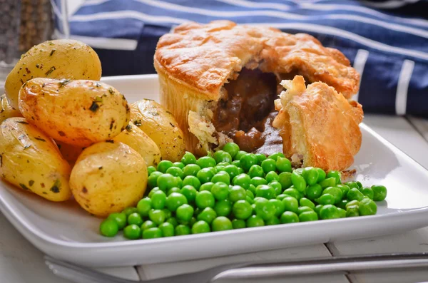 Pastel de carne con papas y guisantes nuevos . —  Fotos de Stock