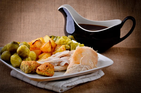 Traditional Sunday dinner with gravy boat. — Stock Photo, Image