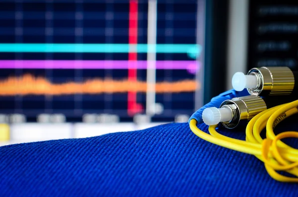 Cable de fibra óptica con analizador de espectro en segundo plano Imagen De Stock