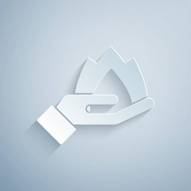 Kağıt kesiği El, gri arka planda izole edilmiş bir ateş ikonu tutuyor. Sigorta konsepti. Güvenlik, güvenlik, koruma, konsept koruma. Kağıt sanatı tarzı. Vektör..