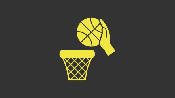 Yellow Hand with basketball ball and basket icon isolated on grey background. Ball in basketball hoop. 4K Video motion graphic animation — Stock Video