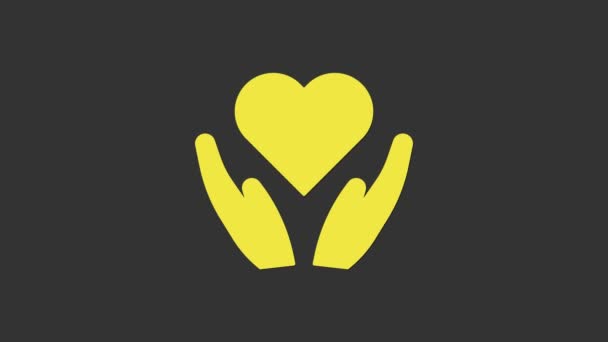 灰色の背景に隔離された手のアイコンに黄色のハート。愛のシンボルを与える手。バレンタインデーのシンボル。4Kビデオモーショングラフィックアニメーション — ストック動画