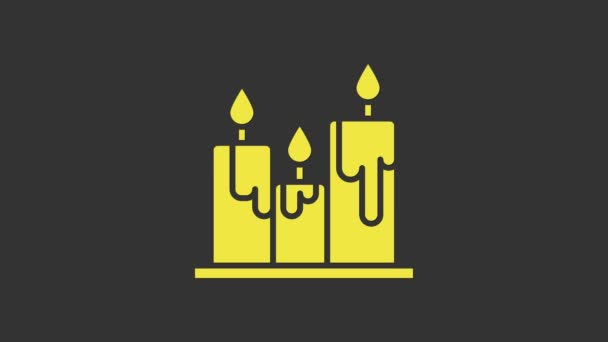 Icono amarillo de velas ardientes aislado sobre fondo gris. Vara cilíndrica con llama ardiente. Animación gráfica de vídeo 4K — Vídeos de Stock