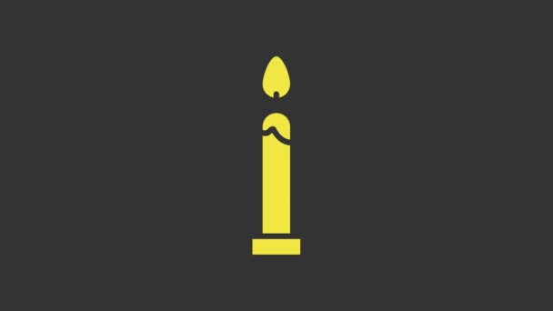 Žlutá ikona hořící svíčky izolované na šedém pozadí. Válcový svícen s hořícím plamenem. Grafická animace pohybu videa 4K — Stock video