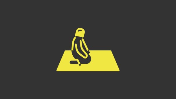 黄色のイスラム教徒の男性は灰色の背景に隔離されたカーペットのアイコンを祈る。4Kビデオモーショングラフィックアニメーション — ストック動画