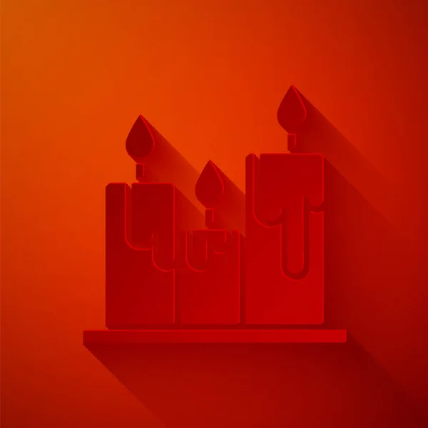 Paper cut Burning candles icon isolated on red background. Cylindrical candle stick with burning flame. Paper art style. Vector Illustration — Stock Vector