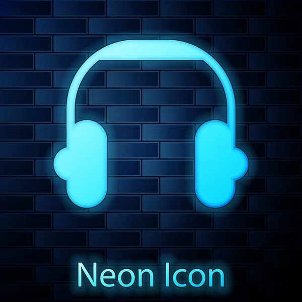 Icono de auriculares de neón brillante aislado en el fondo de la pared de ladrillo. Auriculares. Concepto para escuchar música, servicio, comunicación y operador. Vector — Vector de stock