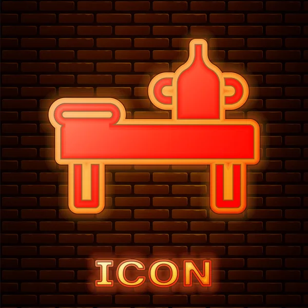 Glowing neon Massage table with oil icon isolated on brick wall background. Vector — Stock Vector