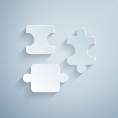 Kağıt kesikli yapboz parçaları, gri arka planda izole edilmiş oyuncak simgesi. Kağıt sanatı tarzı. Vektör