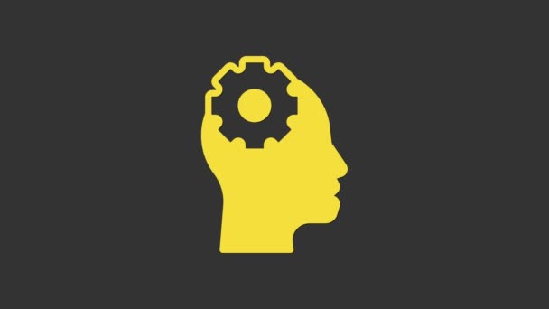 Cabeça humana amarela com engrenagem dentro ícone isolado no fundo cinza. Inteligência artificial. Cérebro pensante. Trabalho simbólico do cérebro. Animação gráfica em movimento de vídeo 4K — Vídeo de Stock