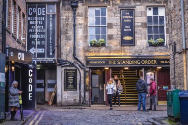 Edinburgh, Scotland - January 17, 2020: People in front of Standing Order pub and CoDE Pod Hostels in Edinburgh city clipart