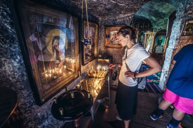 Trebujeni, Moldova - July 16, 2019: Tourist in chapel in monks cave in Old Orhei archaeological park, Trebujeni commune clipart
