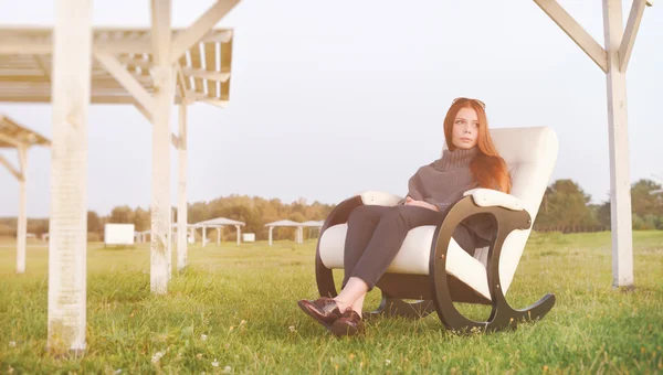 Mooie gelukkig vrouw ontspannen in stoel op lake ochtend Stockfoto