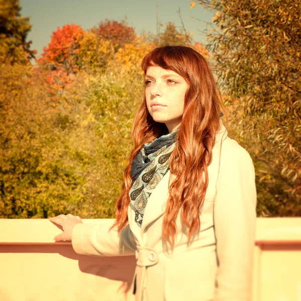 Bella donna con i capelli rossi in autunno parco — Foto Stock