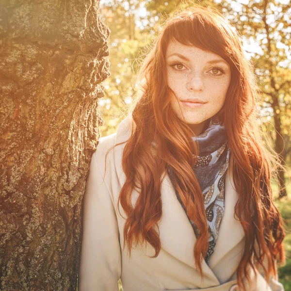 Schöne Frau mit Sommersprossen und roten Haaren im Herbst Park — Stockfoto