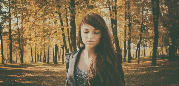 Schöne Frau mit roten Haaren im Herbst Park — Stockfoto