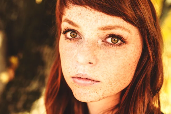 Beautiful woman with freckle and red hair in fall park — Stock Photo, Image