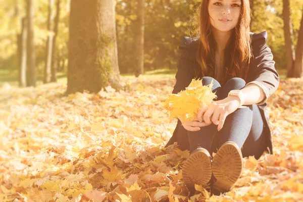 Krásná žena s červenými vlasy spadají park — Stock fotografie