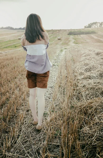 Young beautiful free lonely woman walks across field — Stock Photo, Image