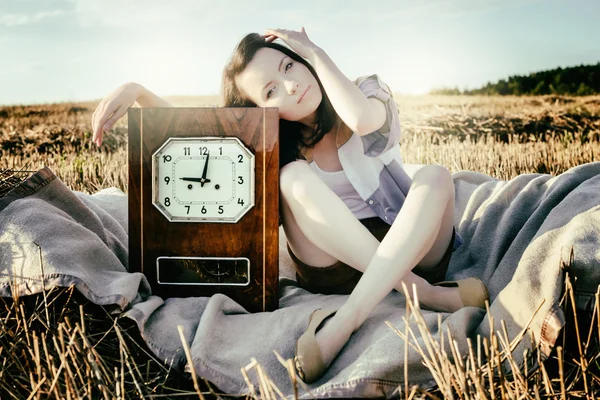 Vacker ovanlig flicka visar begreppsmässig idé med klocka — Stockfoto