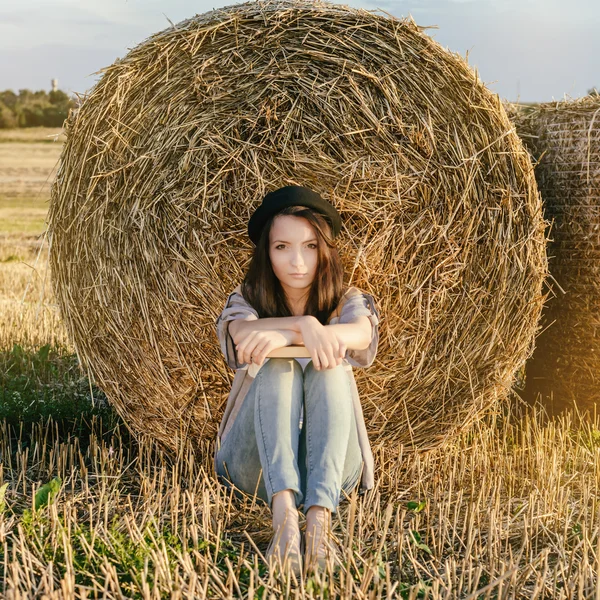 Mooi meisje hipster tegen hooi bale in de herfst — Stockfoto