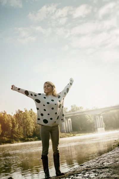 Ensam glad vackra tjej går på flodstranden tidigt på morgonen — Stockfoto