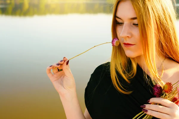 Необычная готическая девушка с длинными рыжими волосами и высохшими цветами — стоковое фото