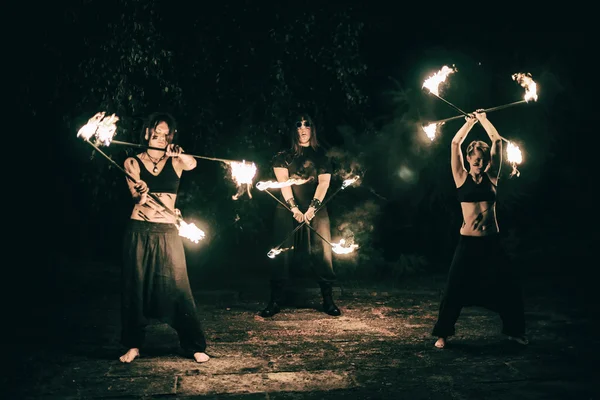 Active girls and boys carries out tricks for fire show at night — Stock Photo, Image