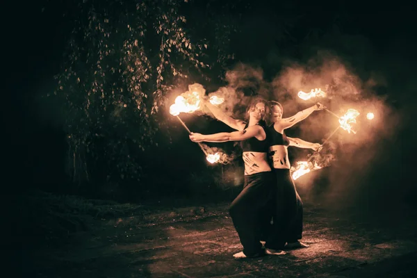 Active girls carries out tricks for fire show at night — Stock Photo, Image