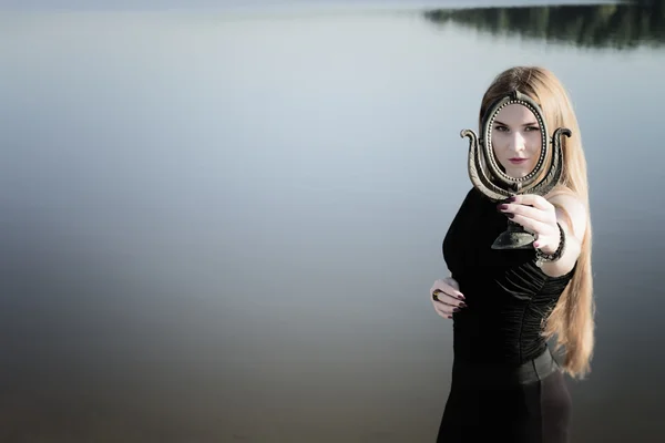 Ragazza gotica con lunghi capelli rossi e vecchio specchio — Foto Stock