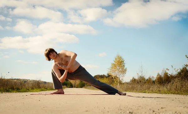 L'homme pratique asanas sur le yoga en harmonie avec la nature — Photo
