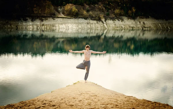 Guy practices asanas on yoga in harmony with nature — Stock Photo, Image