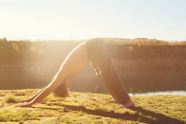 El hombre practica asanas sobre yoga en armonía con la naturaleza — Foto de Stock