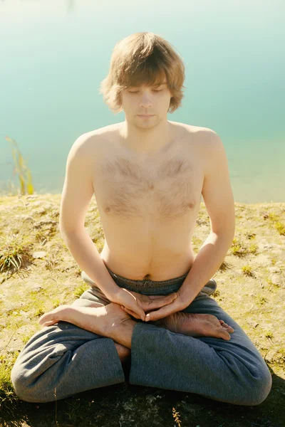 L'homme pratique asanas sur le yoga en harmonie avec la nature Images De Stock Libres De Droits