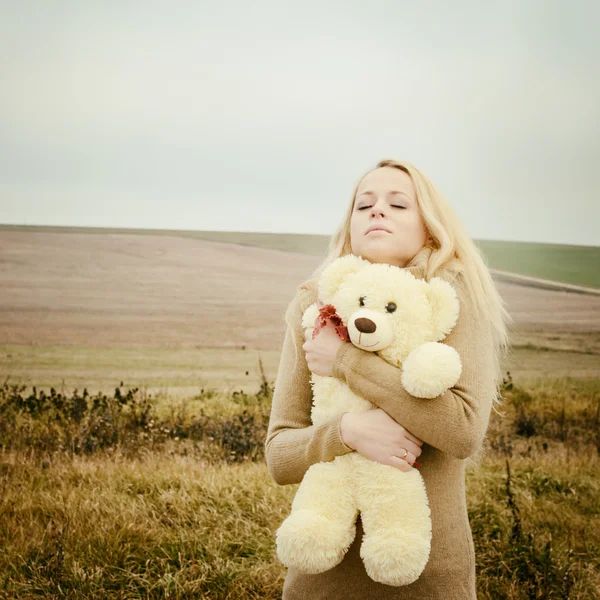 Молодая чувственная блондинка в ветреной осени с игрушкой — стоковое фото