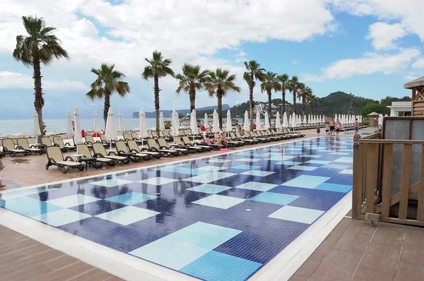 Pool och palmer nära stranden i hotel i Turkiet. — Stockfoto