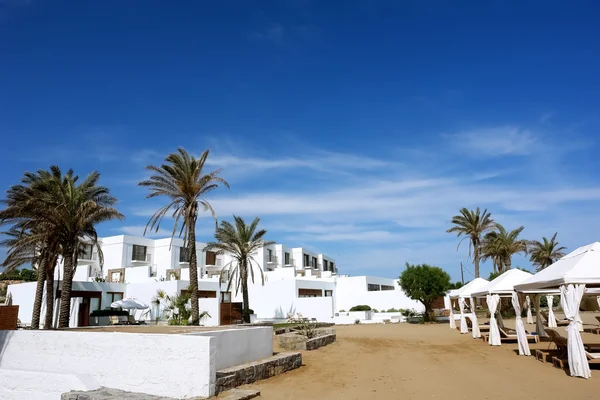 Las villas blancas, palmeras y cielo azul griego . — Foto de Stock