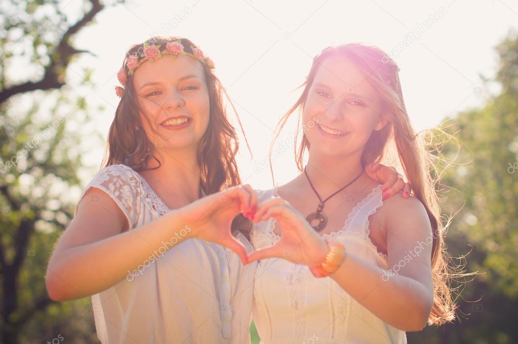 Two girlfriends doing love gesture