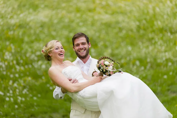 Jardim casamento noivo carregando sua noiva — Fotografia de Stock