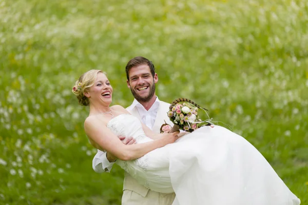 Κήπος γάμος γαμπρός μεταφέρει τη νύφη του Εικόνα Αρχείου