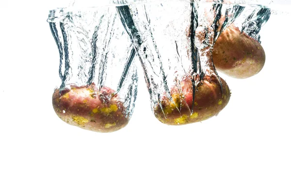 Potatos fall deeply under water — Stock Photo, Image