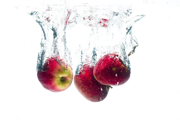 Apples fall deeply under water — Stock Photo, Image