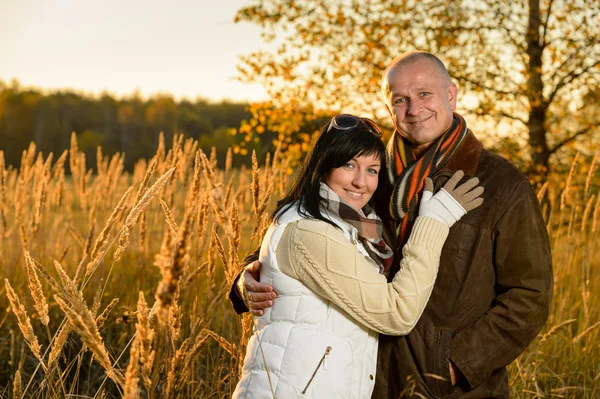 Pareja abrazando en otoño campo puesta de sol Imagen De Stock