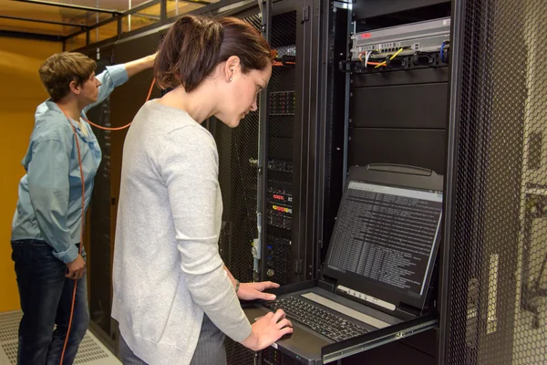 Vrouwelijke technicus in serverruimte — Stockfoto