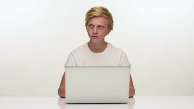 Dizüstü bilgisayarda çalışan bir genç çocuk