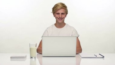 Beyaz üstünde laptop ile gülümseyen genç öğrenci