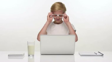 Dizüstü bilgisayar ile masasının başına oturmuş neşeli genç öğrenci