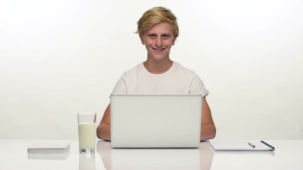 Lachende tiener student met laptop op witte — Stockvideo
