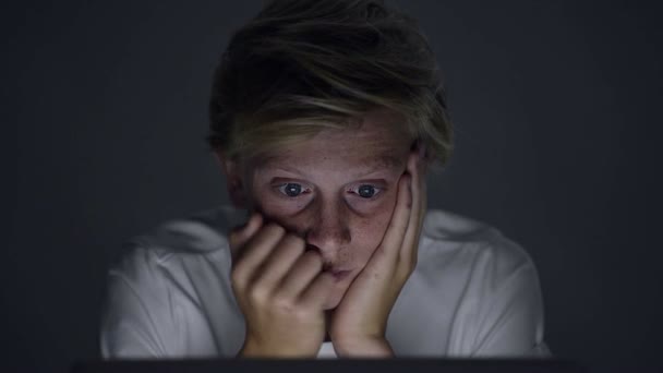Adolescente preocupado mirando la pantalla del ordenador portátil tarde en la noche — Vídeos de Stock